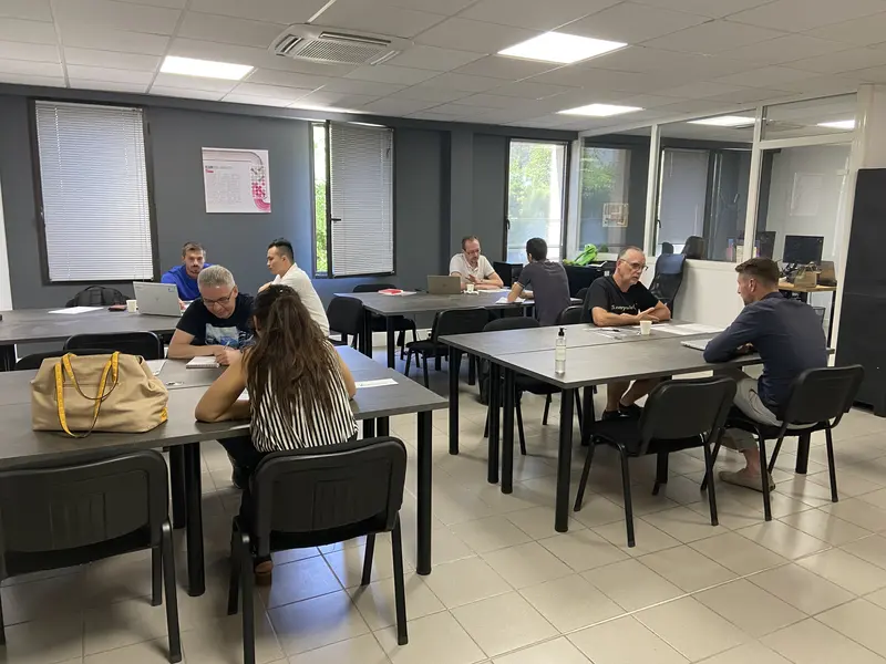 Des apprenants au travail par petits groupes dans une salle de l’école