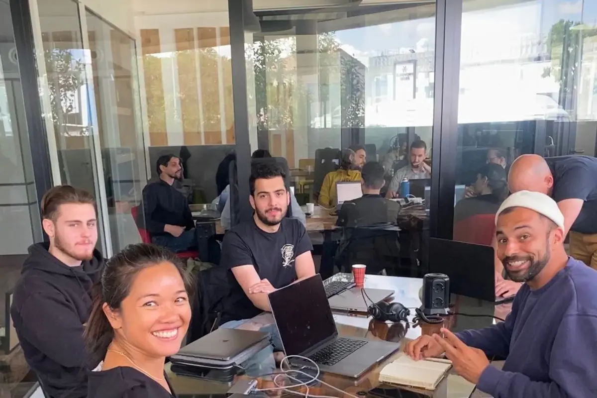 Des étudiants de l’école au travail autour d’une table, ordinateurs ouverts